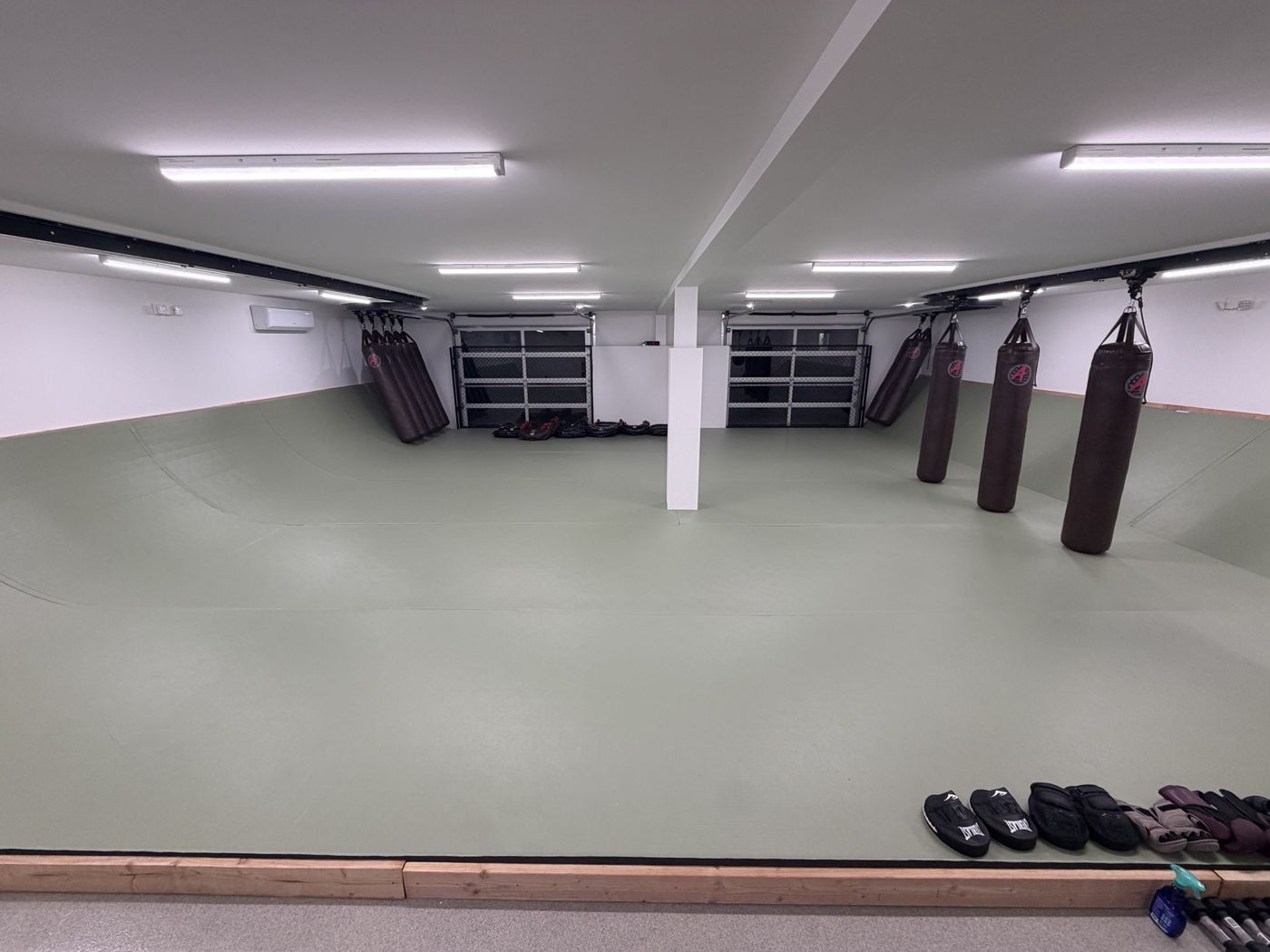 1,400 sq ft mat room with padded angled wall and heavy bags